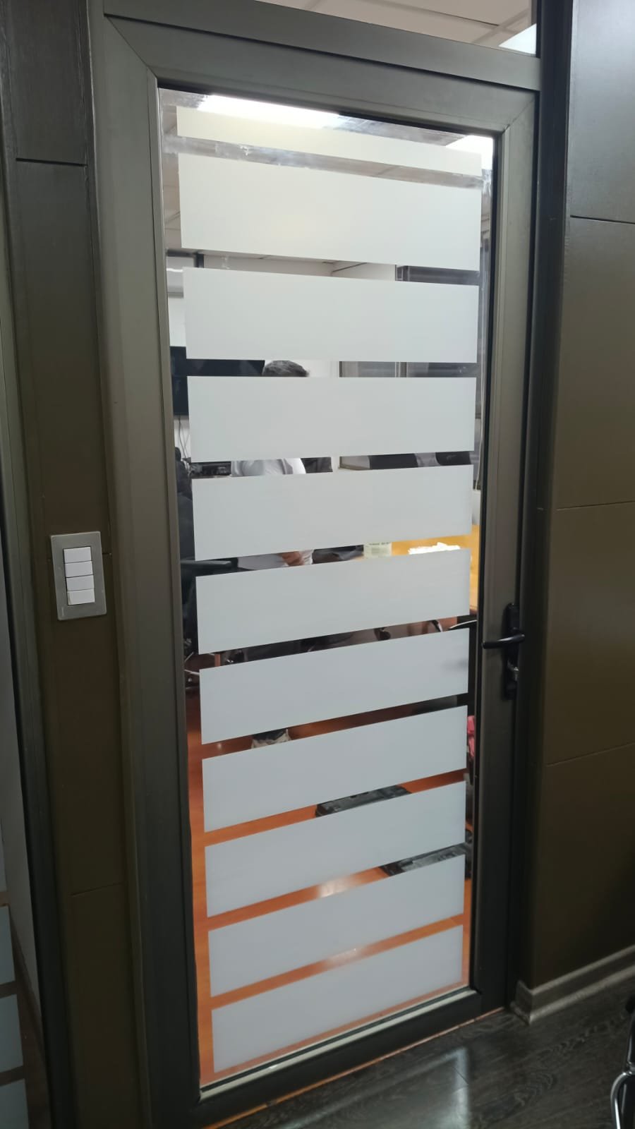 Puerta de vidrio con franjas de privacidad